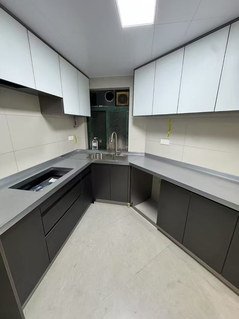 U-shaped residential kitchen with integrated stainless-steel work surfaces